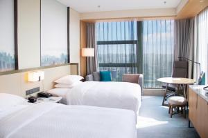 A bed or beds in a room at Four Points by Sheraton Wuhan, Jiangxia