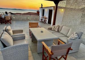 a patio with a couch and chairs and a table at Yulia Luxury Apartments in Ouranoupoli
