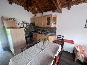 a kitchen with a table and chairs and a refrigerator at Domačija Paternoster in Litija