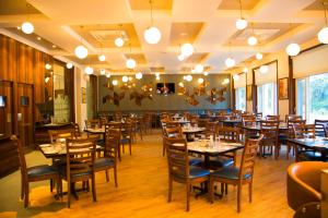 a dining room filled with tables and chairs at 7 Apple Resort, Lonavala in Lonavala