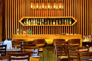a restaurant with a bar with chairs and bottles of wine at 7 Apple Resort, Lonavala in Lonavala