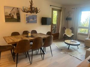 a dining room with a wooden table and chairs at Arc 1950 Ski in Ski out and Spa- Newly refurbished 153 Sources De Marie- 2 bedroom , 2 bathroom-Sleeps 4-6, Mont Blanc view from every window, Free WiFi in Arc 1950