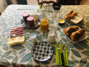 a table topped with breakfast foods and orange juice at Le Logis du Gast chambre verte in Le Gast