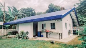 une petite maison blanche avec un toit bleu dans l'établissement Beach House, San Juan, La Union, à San Juan