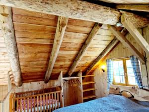 ein Schlafzimmer mit Holzdecken und ein Bett in einem Zimmer in der Unterkunft Experience this unique wooden house! in Seltenheim