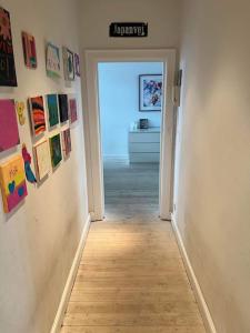 a hallway with paintings on the walls of a room at Familievenlig lejlighed tæt på Amager Strand in Copenhagen