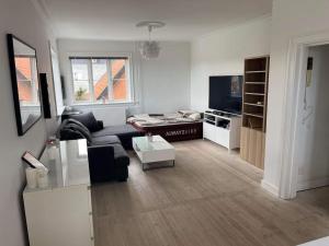 een woonkamer met een bank en een tv bij Familievenlig lejlighed tæt på Amager Strand in Kopenhagen