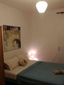 sypialnia z łóżkiem i obrazem na ścianie w obiekcie Zeta's house Argalasti w mieście Argalasti