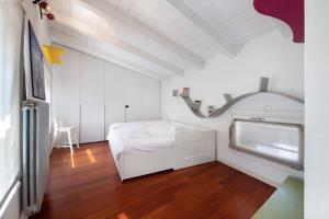 a white room with a bed and a table at Penthouse in Città Alta - Bergamo in Bergamo