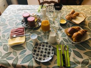 a table topped with breakfast foods and orange juice at Le Logis du Gast chambre rose in Le Gast