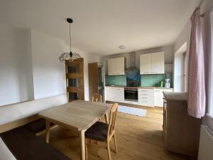een keuken en eetkamer met een houten tafel en stoelen bij Villa Hansalhof, Wohnung Rosenduft in Mariapfarr +23 foto's