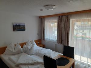 um quarto com uma cama, uma mesa e uma janela em Grünwaldhof em Tux