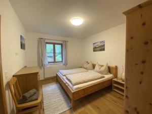 een slaapkamer met een bed en een raam bij Villa Hansalhof, Wohnung Rosenduft in Mariapfarr