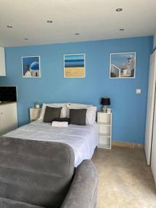 a blue bedroom with a bed and a couch at Summer guest house with hottub and BBQ area in Winchmore Hill