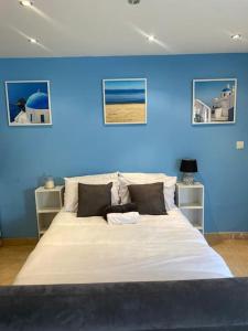 Un dormitorio con una pared azul y una cama grande en Summer guest house with hottub and BBQ area, en Winchmore Hill