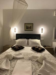 1 dormitorio con 1 cama con toallas en Karaoulanis Beach, en Agios Ioannis
