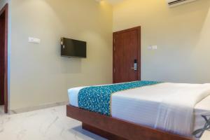 a bedroom with a bed and a tv on the wall at The Kamoda Resort in Ambikāpur