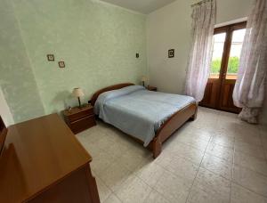 una camera con letto, scrivania e finestra di Casa Serbariu, Sud Sardegna - Carbonia a Carbonia