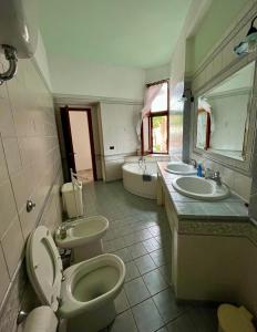 a bathroom with two sinks and a toilet and a tub at Casa Serbariu, Sud Sardegna - Carbonia in Carbonia