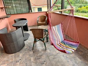 a hammock on a patio with chairs and a table at Casa Serbariu, Sud Sardegna - Carbonia in Carbonia
