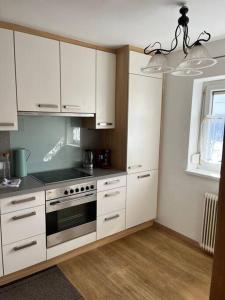 a kitchen with white cabinets and a stove at Garden View Apartment in Innsbruck