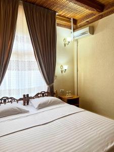 - une chambre avec un grand lit et une fenêtre dans l'établissement Hotel Caravan Serail, à Samarcande
