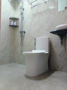 La salle de bains est pourvue de toilettes blanches. dans l'établissement Tropical stay Thulusdhoo, à Thulusdhoo