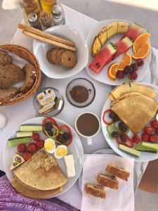 einen Tisch mit Teller mit Lebensmitteln drauf in der Unterkunft Monel Hotel in Ksamil