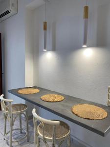 - un comptoir avec 4 chaises et une table avec des pizzas dans l'établissement Karaoulanis Beach, à Agios Ioannis