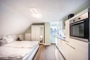 a bedroom with a bed and a kitchen with a sink at Salty Sol in Leutkirch im Allgäu