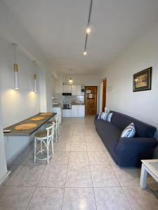 Il comprend un salon avec un canapé bleu et une cuisine. dans l'établissement Karaoulanis Beach, à Agios Ioannis
