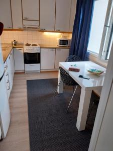 a kitchen with a table and a white table and chairs at Cozy Aparti in Vantaa