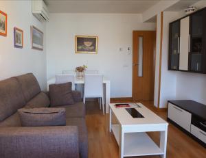 - un salon avec un canapé et une table dans l'établissement Apartamentos La Muralla, à Zamora