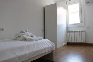 a white bedroom with a bed and a window at MonResidence Bellavista in Manresa