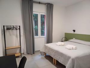 een slaapkamer met 2 bedden en een raam bij B&B NAR in Como