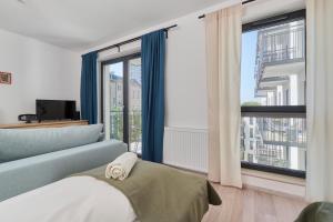 um quarto com um sofá azul e uma grande janela em City Center Mirrors Apartment with Parking by Renters em Breslávia
