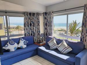 a blue couch in a living room with a view of the ocean at Gooderson Leisure Silver Sands 1 Self Catering and Timeshare Lifestyle Resort in Durban