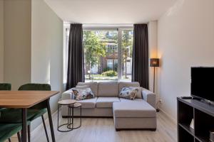 een woonkamer met een bank en een tafel bij Hertog 1 Modern and perfectly located apartment in Eindhoven
