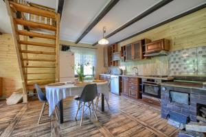 a kitchen with a table and chairs in a room at Domek z Piernika 729-656-514 in Ropienka