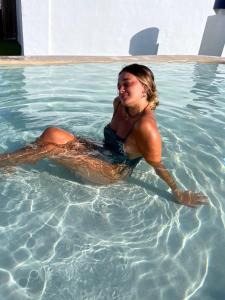 a woman laying on her back in a swimming pool at Hotel Porto in Gandía