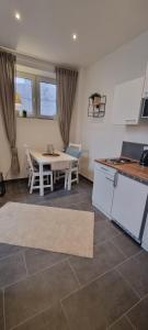 a kitchen with a white table and a table and chairs at Apartment Hallenbach in Zell an der Mosel