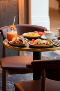 a table with plates of food and a drink on it at Hotel Pulitzer Paris in Paris