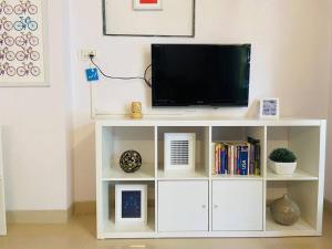 a white entertainment center with a television on top at Matruchaya, off Carter Road by Connekt Homes in Mumbai