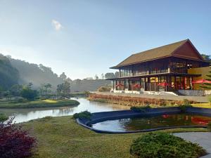 湄林蒙查温泉旅馆的建筑物前有池塘的建筑物