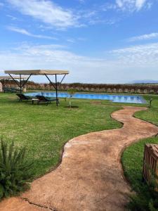 - une piscine avec une table de pique-nique et un pavillon à côté d'une rivière dans l'établissement Heart and Soul Lodge, à Karatu