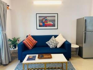 a living room with a blue couch and a coffee table at Matruchaya, off Carter Road by Connekt Homes in Mumbai +19 photos