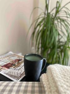 a black coffee cup sitting on a table with a magazine at Zentrales Privatapartment in Bad Homburg vor der Höhe