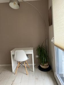 a white chair sitting next to a desk with a lamp at Zentrales Privatapartment in Bad Homburg vor der Höhe