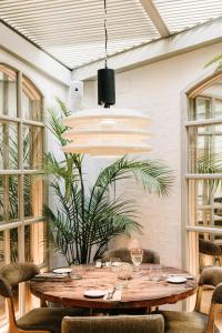 バルセロナにあるHotel Pulitzer Barcelonaの食卓と鉢植えの植物があるダイニングルーム