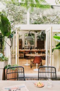 una sala da pranzo con piante e tavolo e sedie di Hotel Pulitzer Barcelona a Barcellona